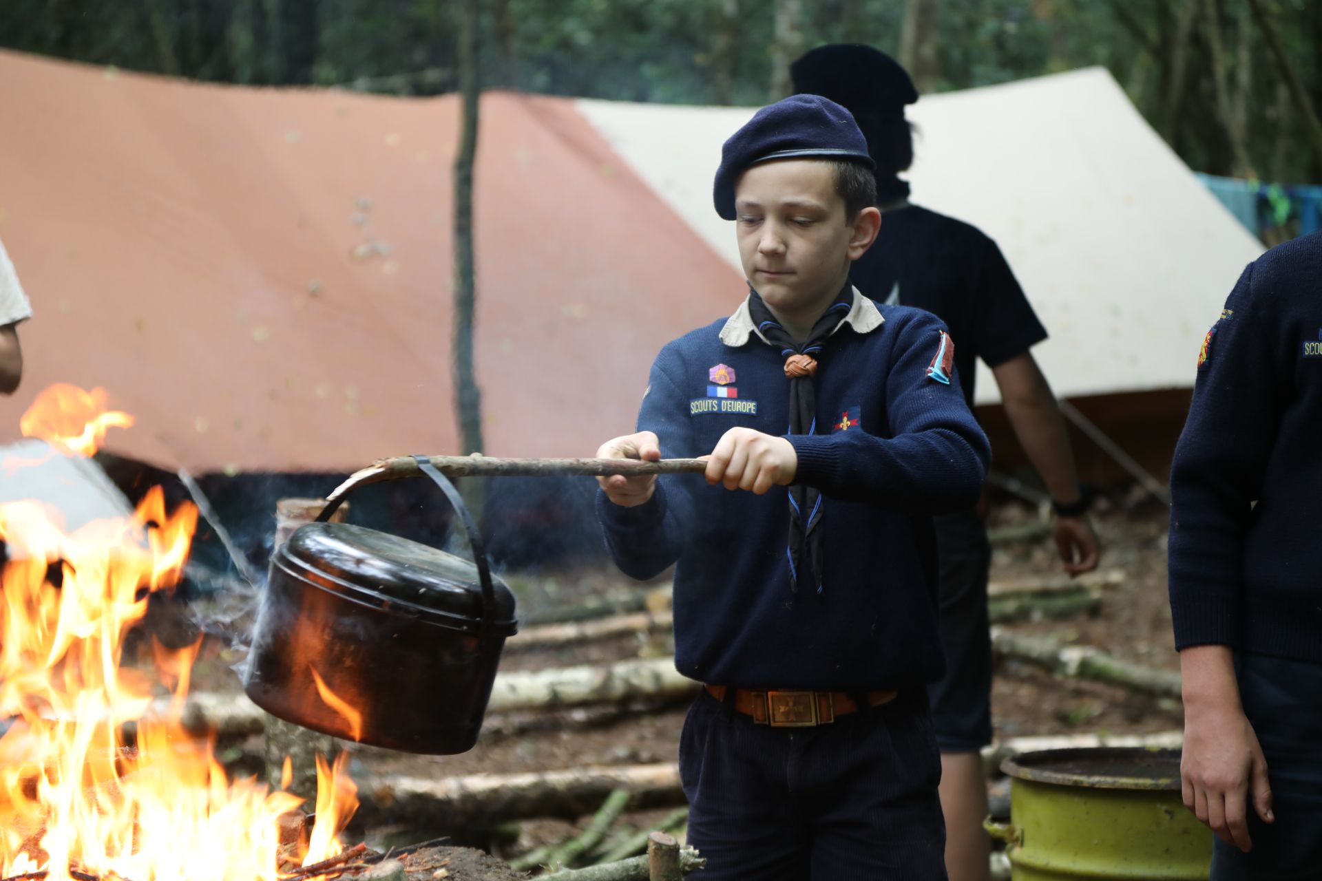 Scout cuisinant sur le feu de vois