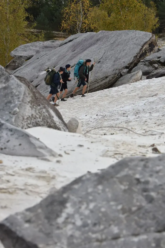 Marche lors d'un raid parmis des gros rocher pour ces scouts